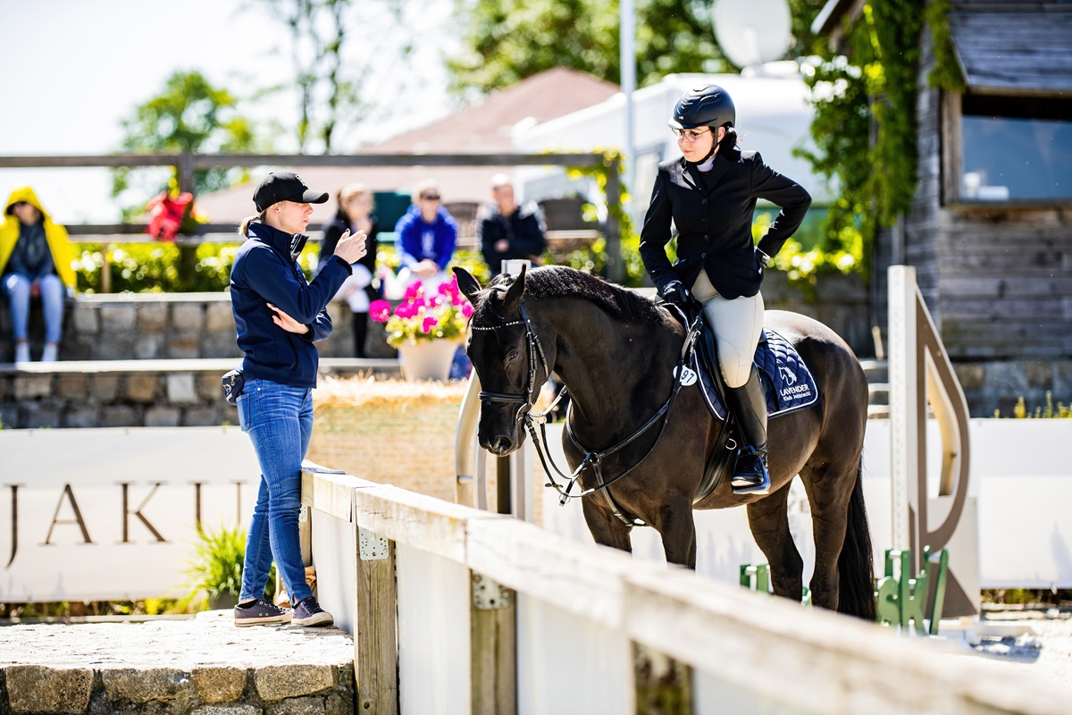 trener i jezdziec z koniem podczas zawodow konnych